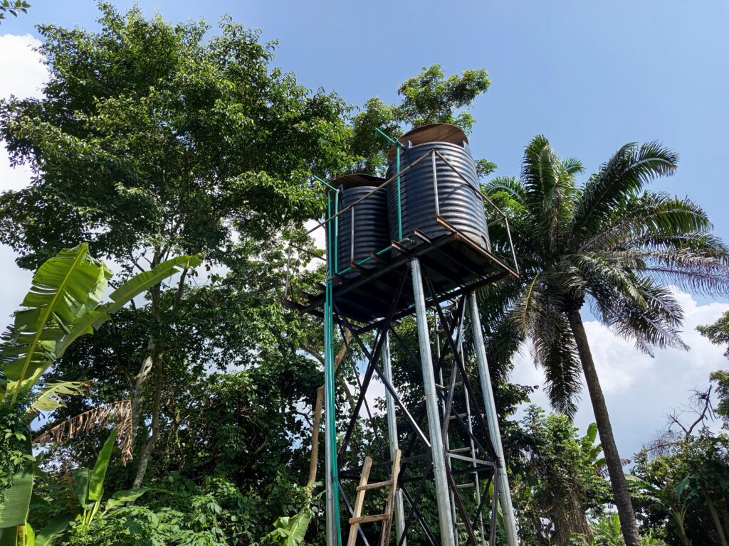 A 4000-liter water tank on a high stand with rainwater harvesters